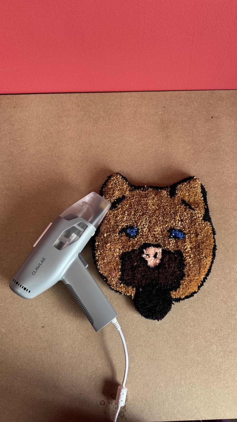 Close-up of a tufting gun mid-stitch on a bear-shaped patch
