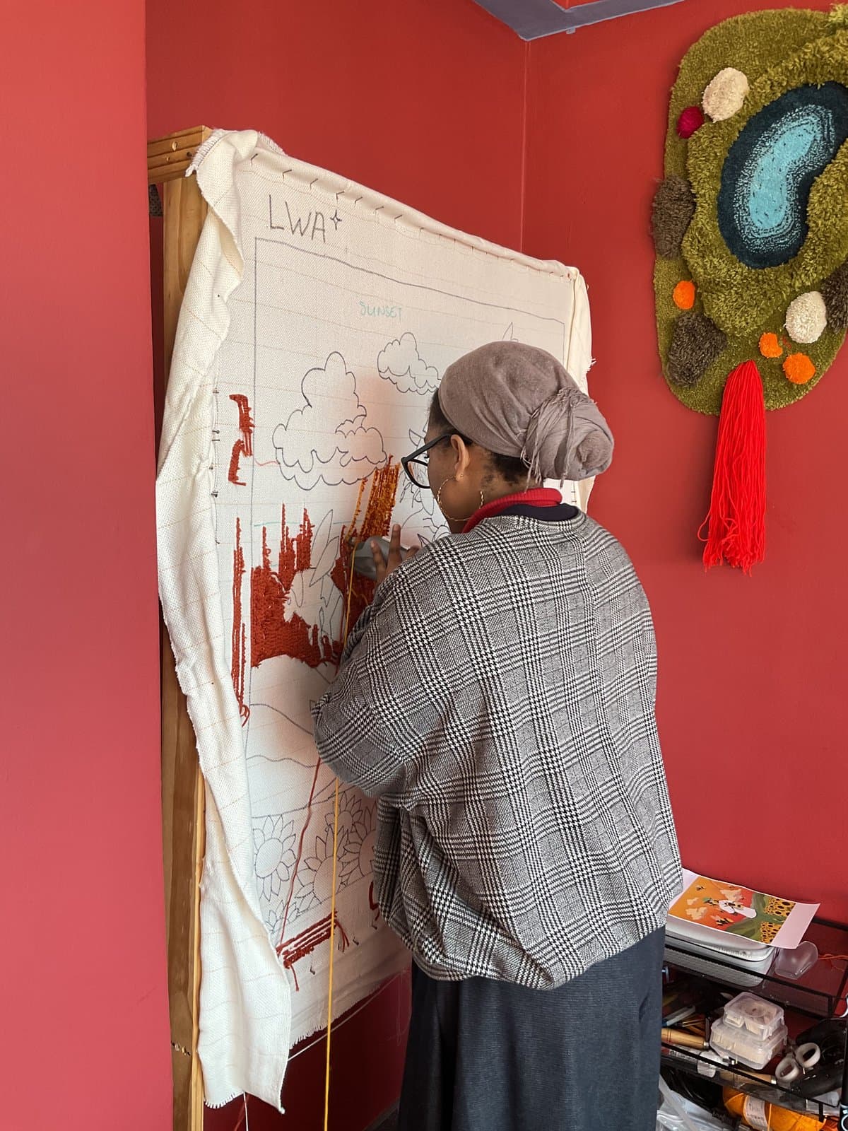 Instructor guiding a student through a tufted design