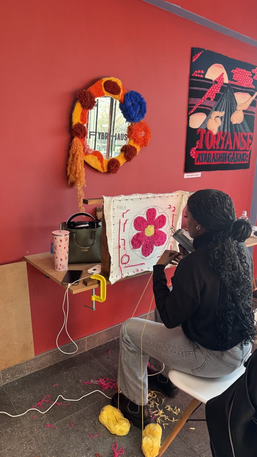 Student tufting a pink flower design at the frame